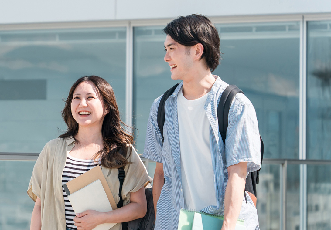 晴れた日に笑顔で並んで歩く若い男女