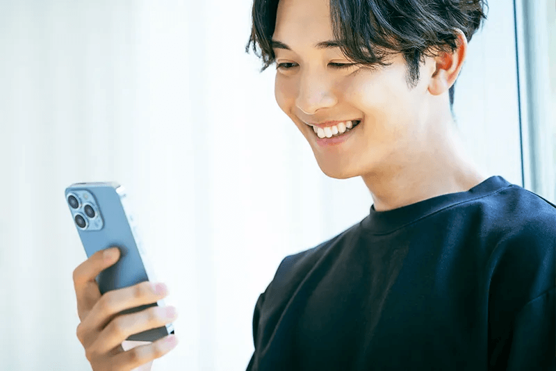 スマートフォンでWeb問診票を入力する男性の様子